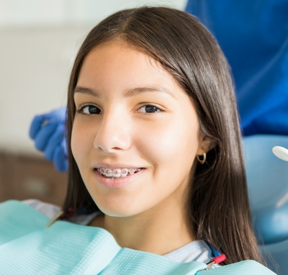 Young woman with braces smiling in dental chair